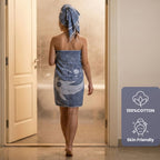 Person wrapped in a blue towel with a towel rack in the background, featuring a '100% Cotton' and 'Skin Friendly' label. VU-YNG-IND
