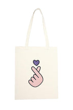 Tote bag with a pink hand making a heart shape and a purple heart on a white background
