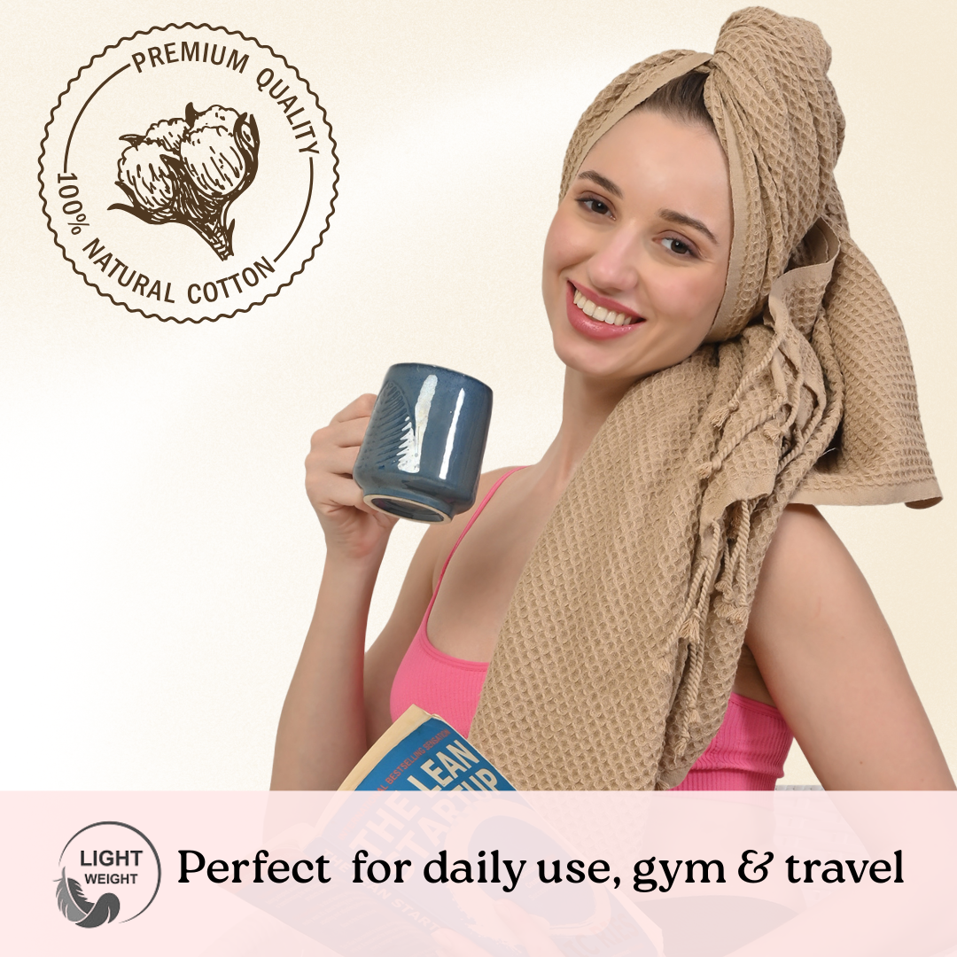 Woman wearing a beige waffle towel holding a mug with text about premium quality natural cotton and light weight.(  PT-WFL-BIS)