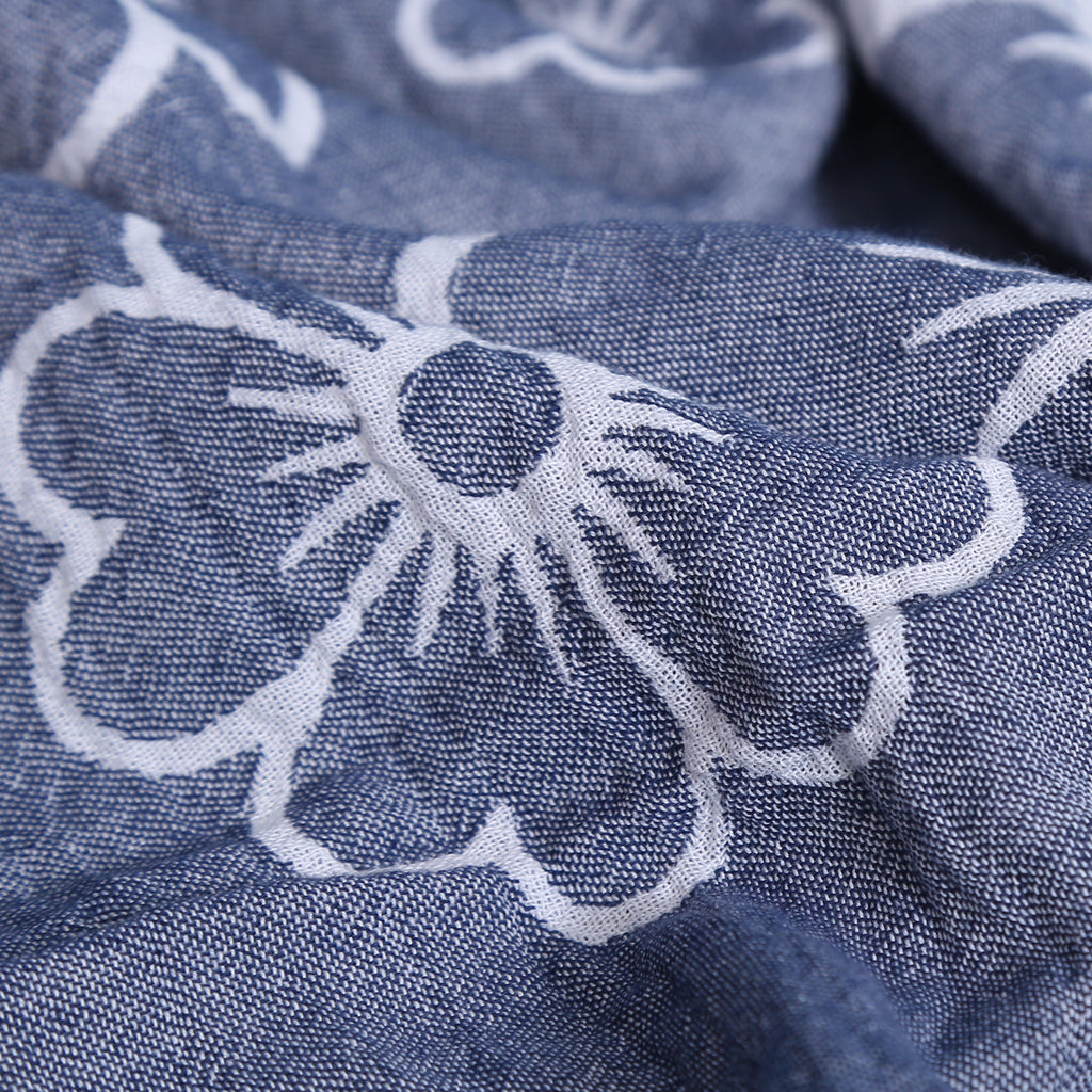 Close-up of blue fabric with white floral embroidery VU-BLO-IND