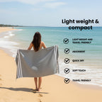 Person on a beach with a emarald bamboo towel, featuring text about towel properties.(PT-BMB-EMR)