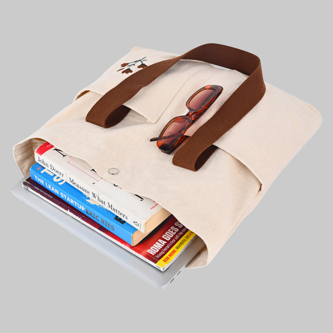 Beige cotton bag with brown strap holding books with beautiful flower embroidery (PT-TRO-BRW)