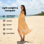 Woman wrapped in a mustard bamboo towel on a beach with text highlighting towel features.(PT-BMB-MST)